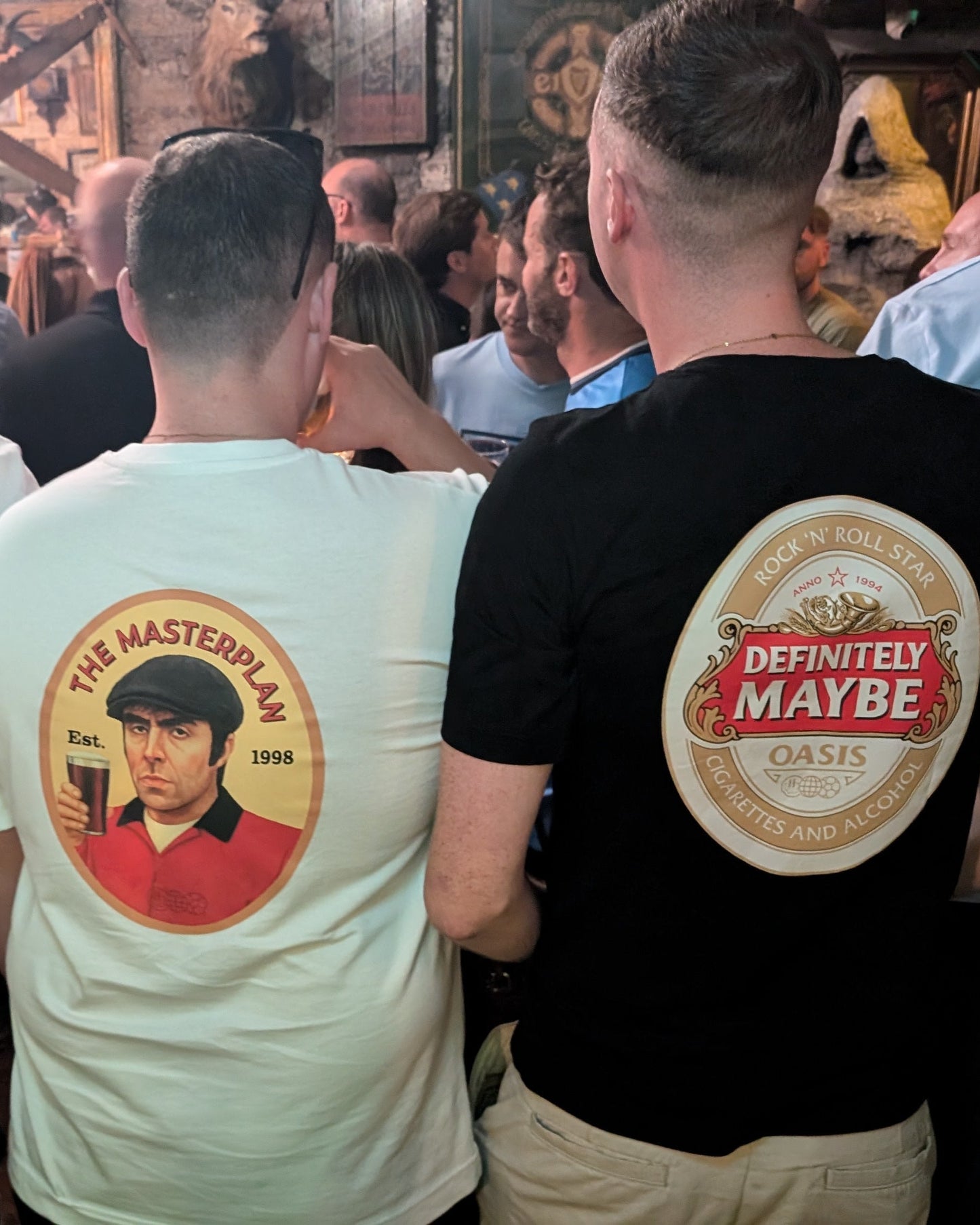 People in a bar wearing t-shirts with various designs and text.