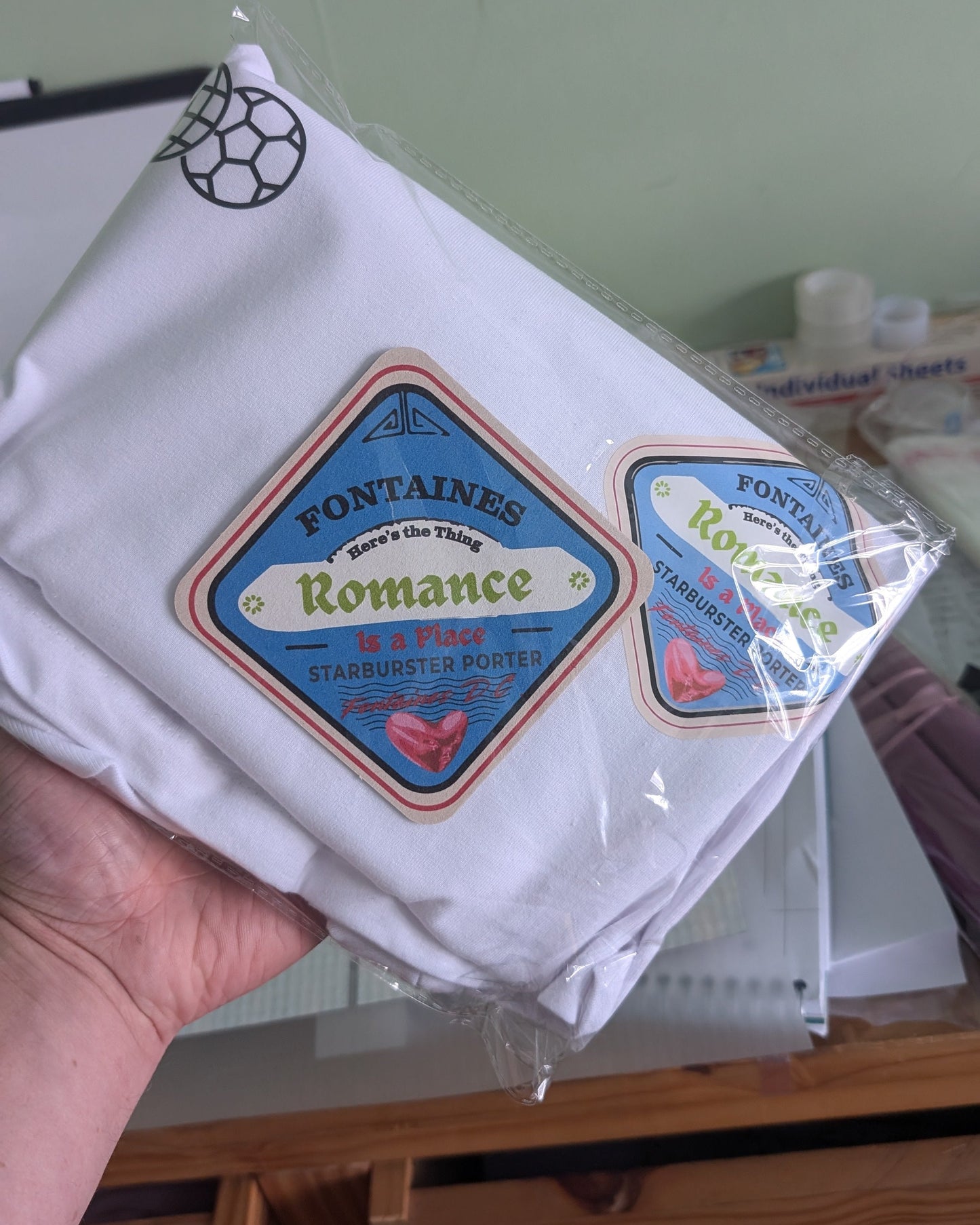 Packaged product labeled 'Fontaines Romance' held by a hand with a blurred background.