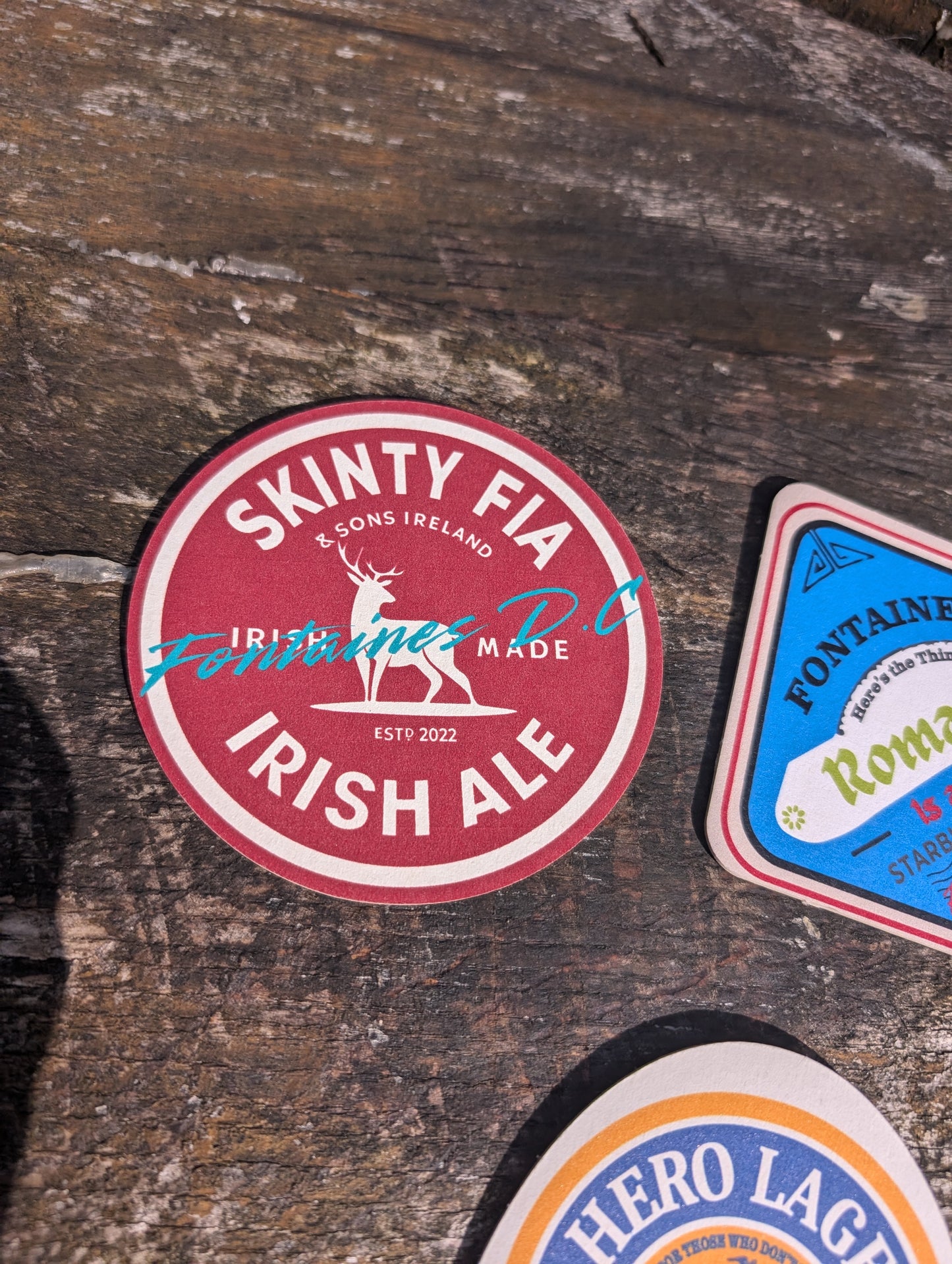 Skinty Fia Irish Ale label on a wooden surface with other labels.