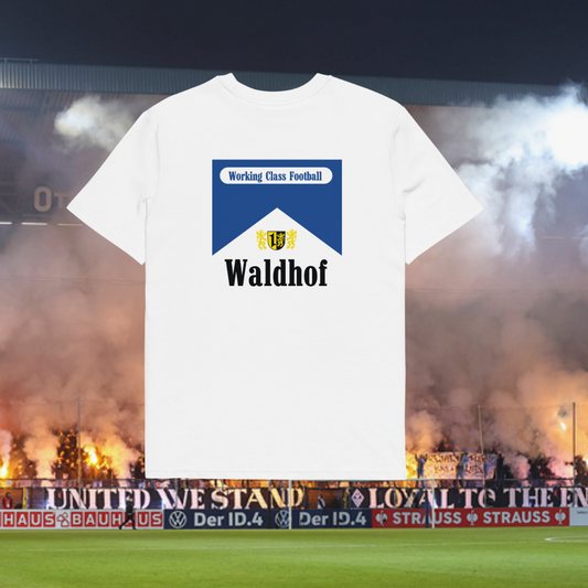 A white t-shirt with 'Working Class Football' and 'Waldhof' printed on the back, displayed in front of a football stadium with fans and banners.